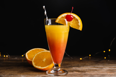 Photo of Fresh alcoholic Tequila Sunrise cocktail on wooden table