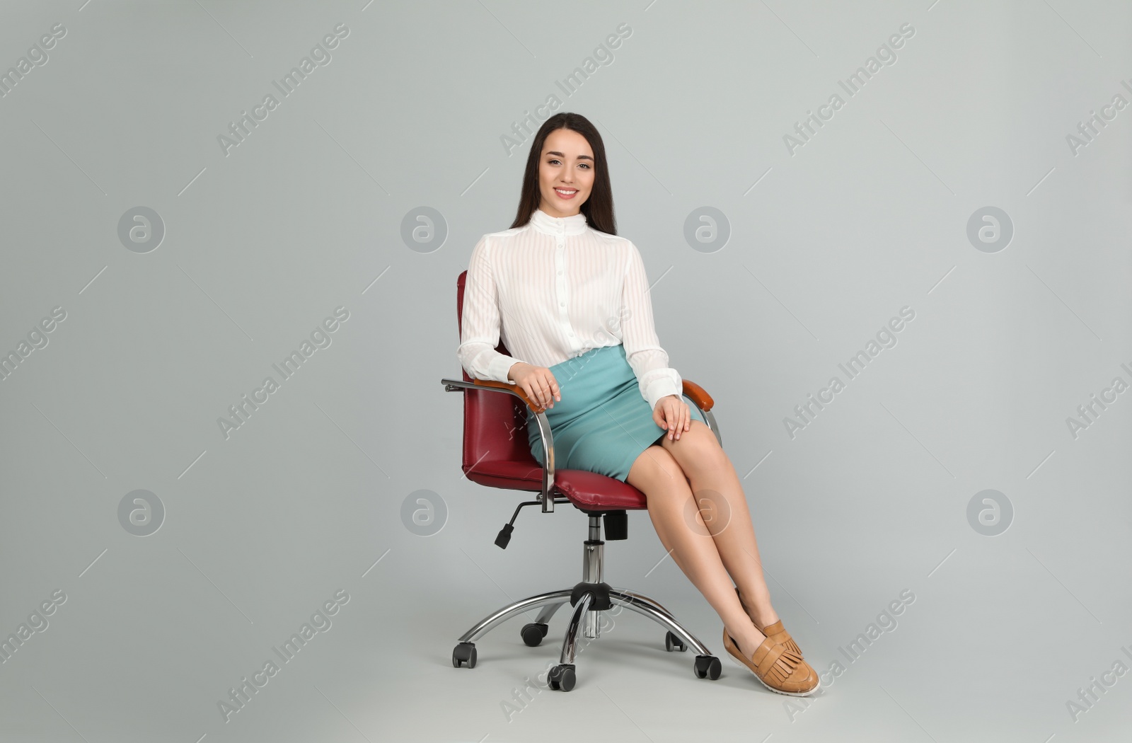 Photo of Young businesswoman sitting in comfortable office chair on grey background