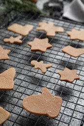 Homemade Christmas cookies. Baking rack with raw gingerbread biscuits on grey table, closeup