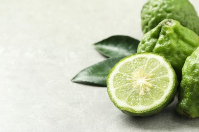 Photo of Fresh ripe bergamot fruits on light grey table, space for text