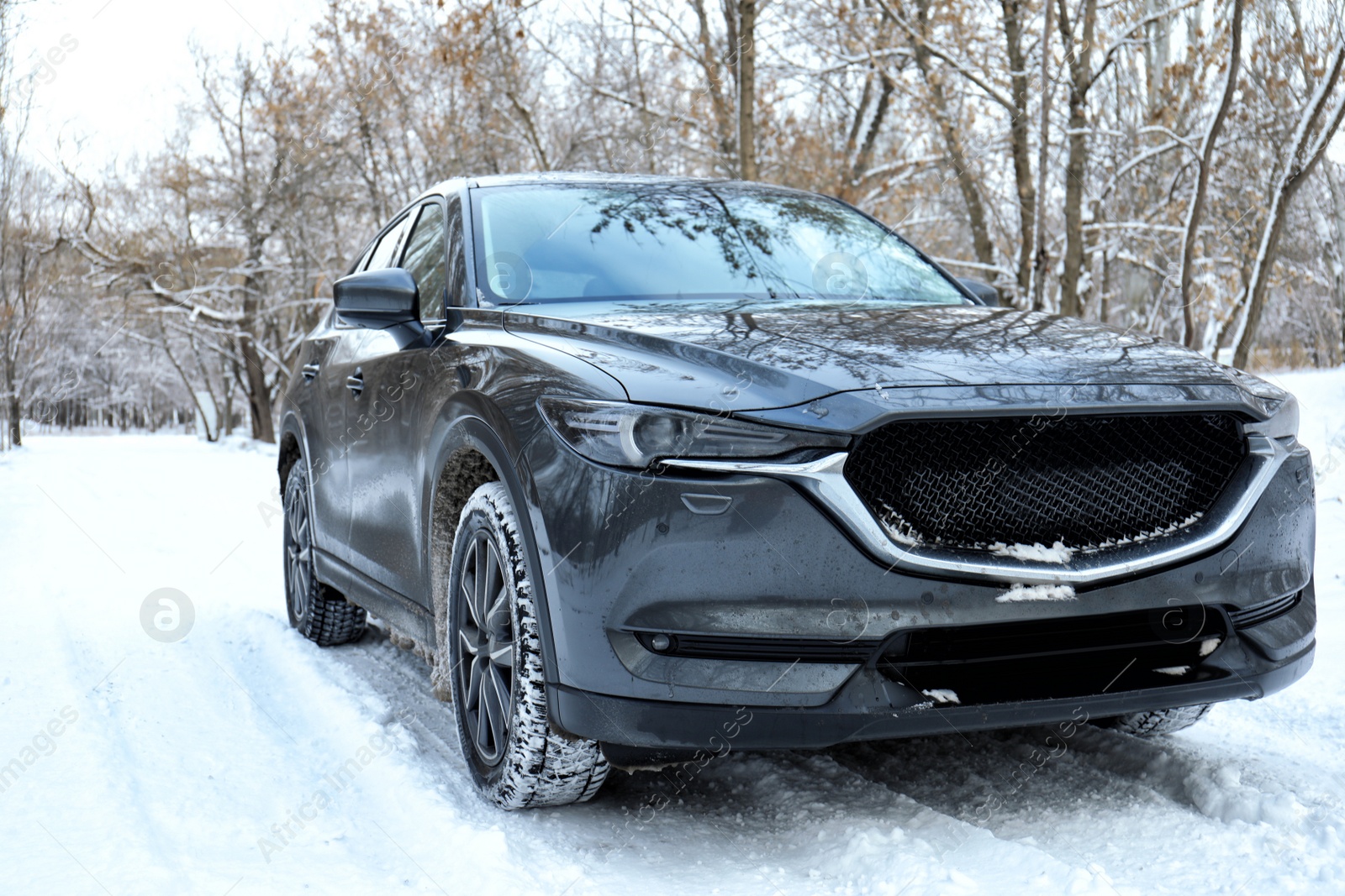 Photo of Snowy country road with car on winter day