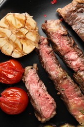 Photo of Delicious grilled beef steak with vegetables and spices on plate, top view