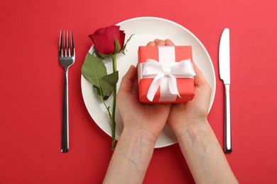 Photo of Woman setting table for Valentine's Day dinner, top view