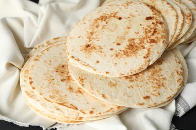 Tasty homemade tortillas and cloth on table