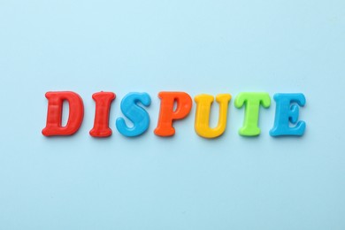 Photo of Word Dispute made of colorful letters on light blue background, flat lay