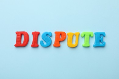 Word Dispute made of colorful letters on light blue background, flat lay