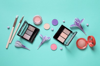 Flat lay composition with different makeup products and beautiful flowers on light turquoise background