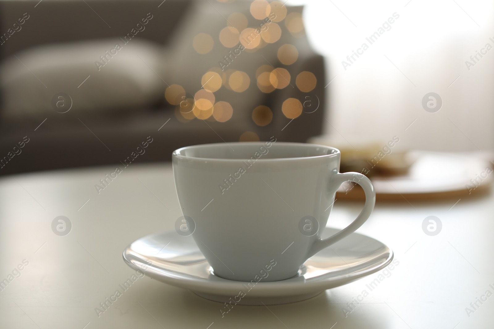 Photo of Cup of aromatic coffee on table indoors. Bokeh effect