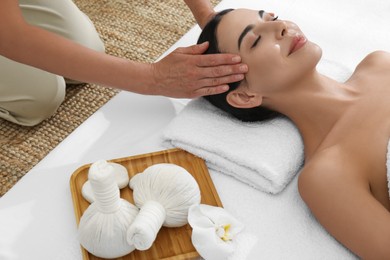 Photo of Young woman receiving facial massage in spa salon