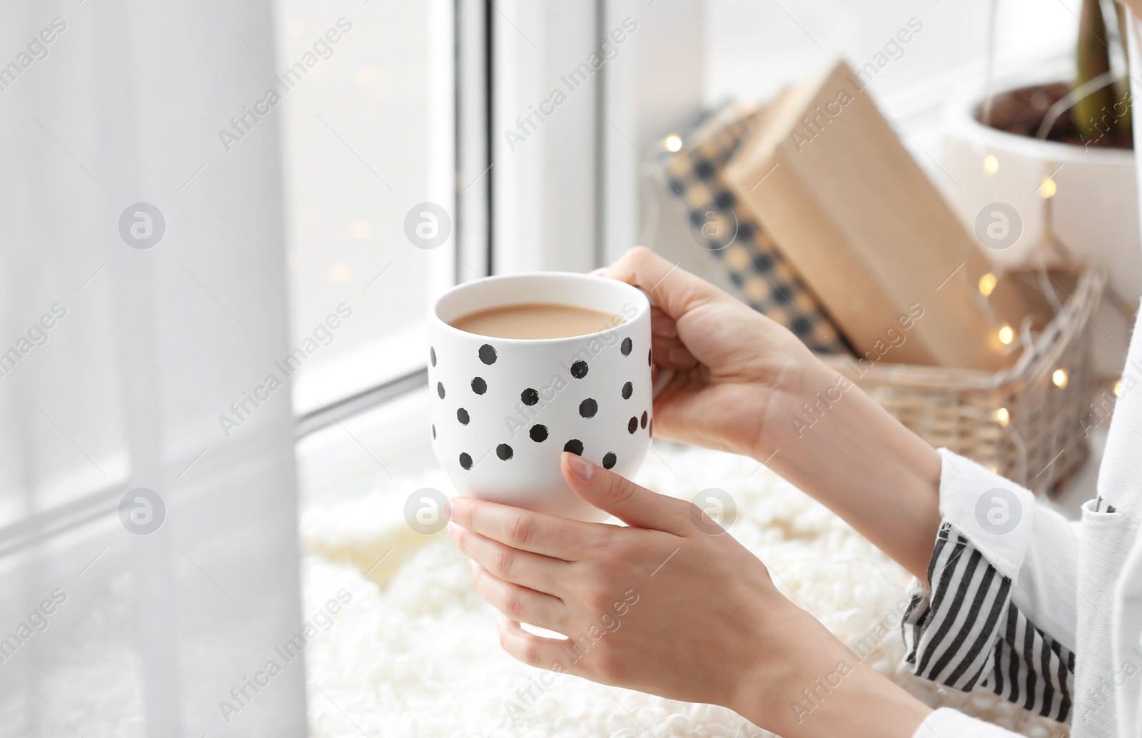 Photo of Morning of young woman with cup of hot coffee at home