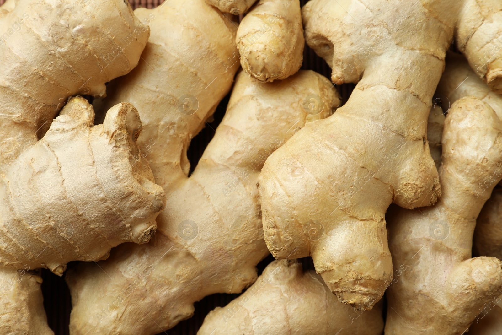 Photo of Aromatic fresh ginger as background, closeup view