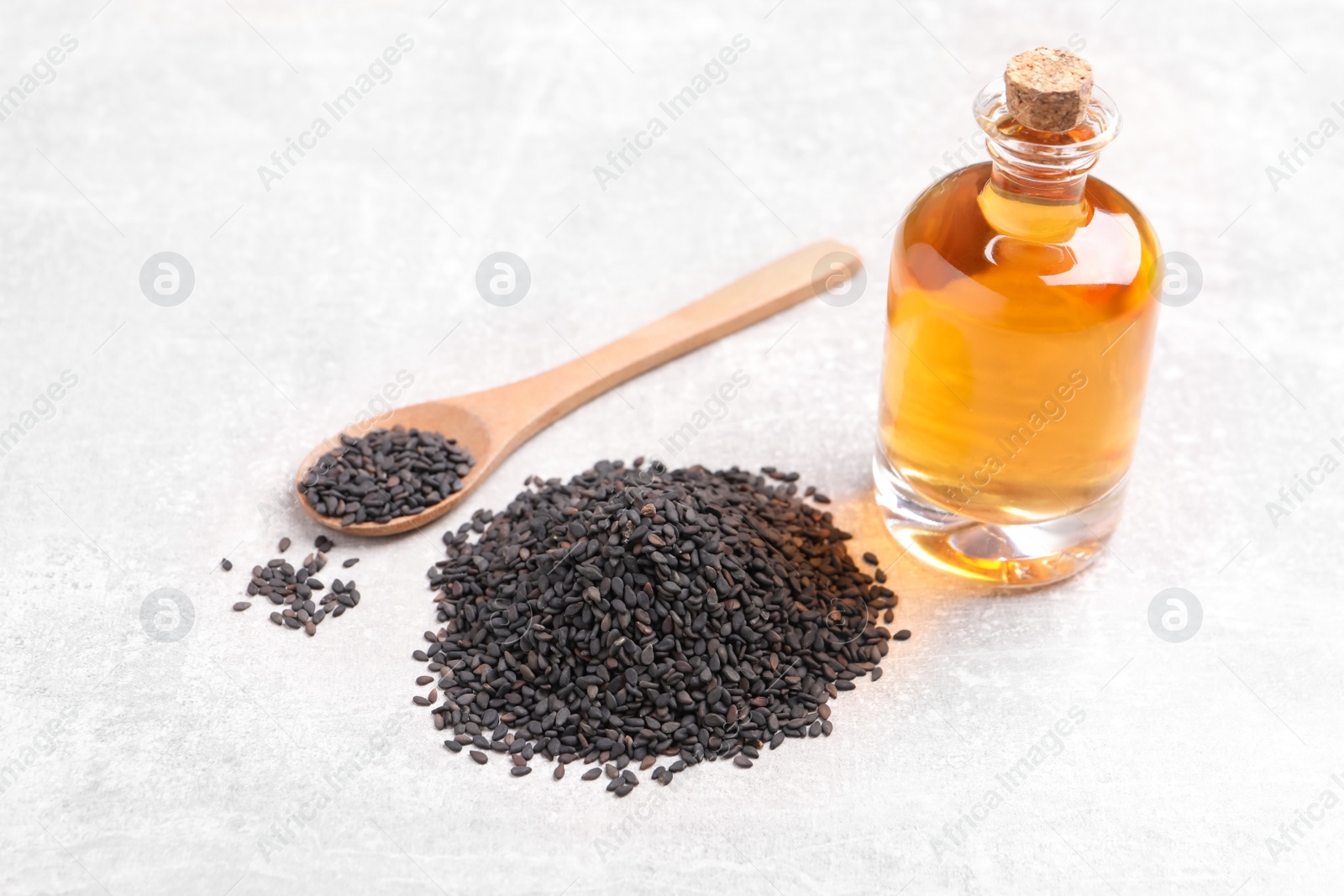 Photo of Black sesame seeds and oil on light table