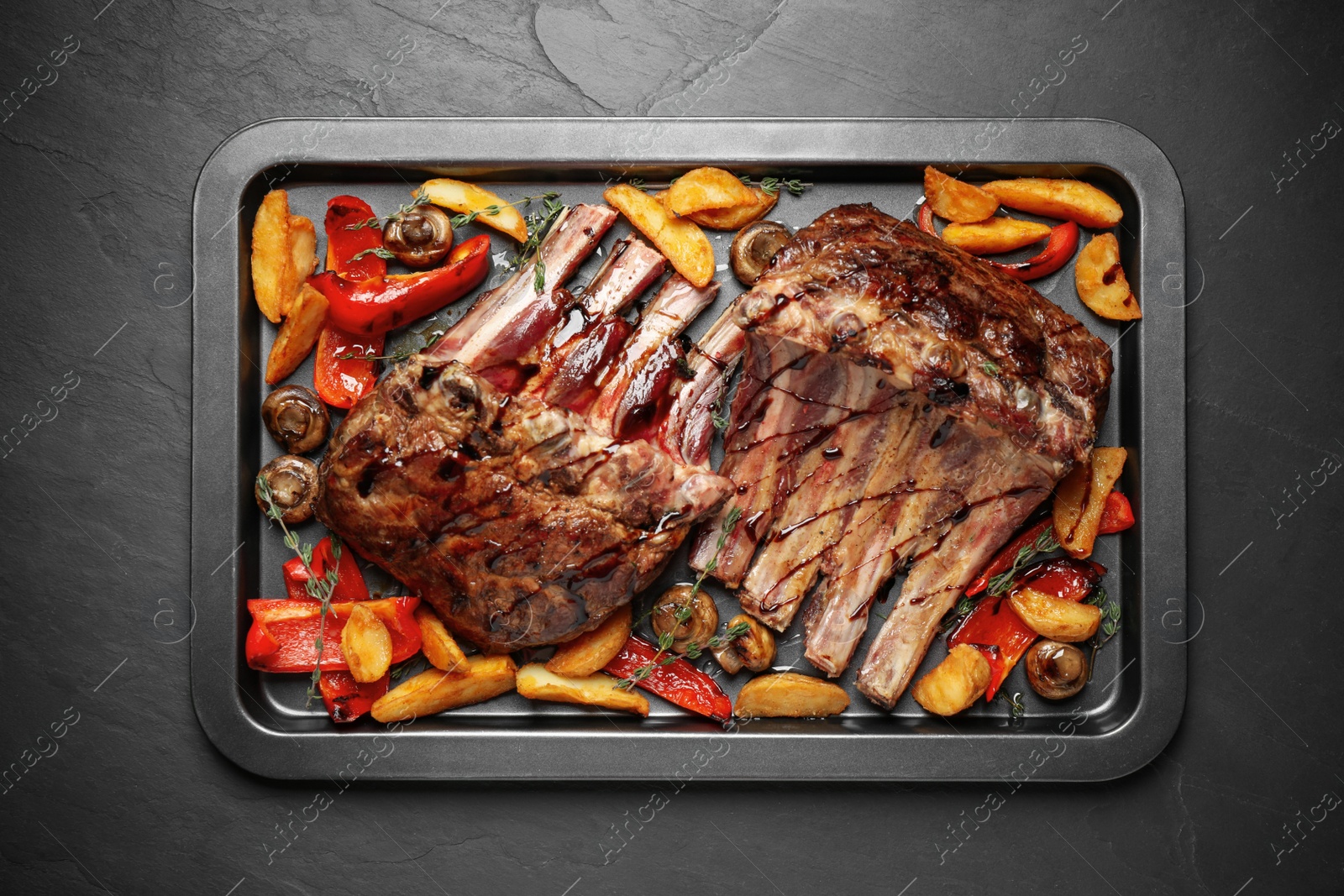 Photo of Delicious roasted ribs with garnish, top view