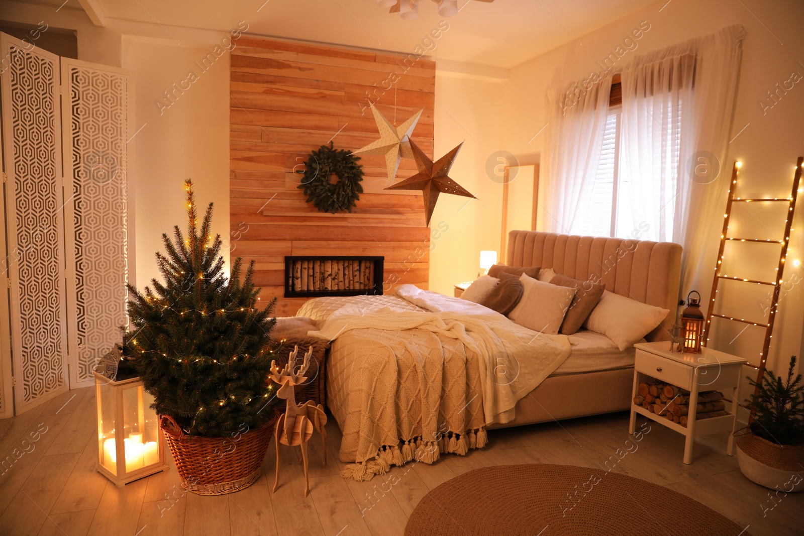 Photo of Beautiful decorated Christmas tree with fairy lights in bedroom interior