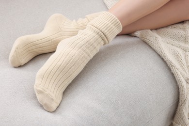 Woman in warm socks lying on sofa, closeup