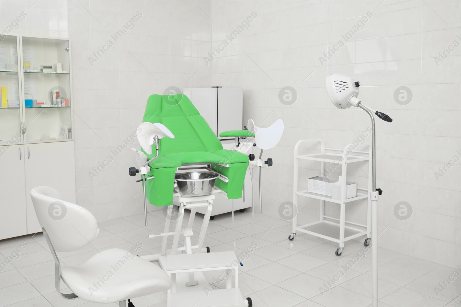 Photo of Modern gynecological office interior with examination chair and medical equipment