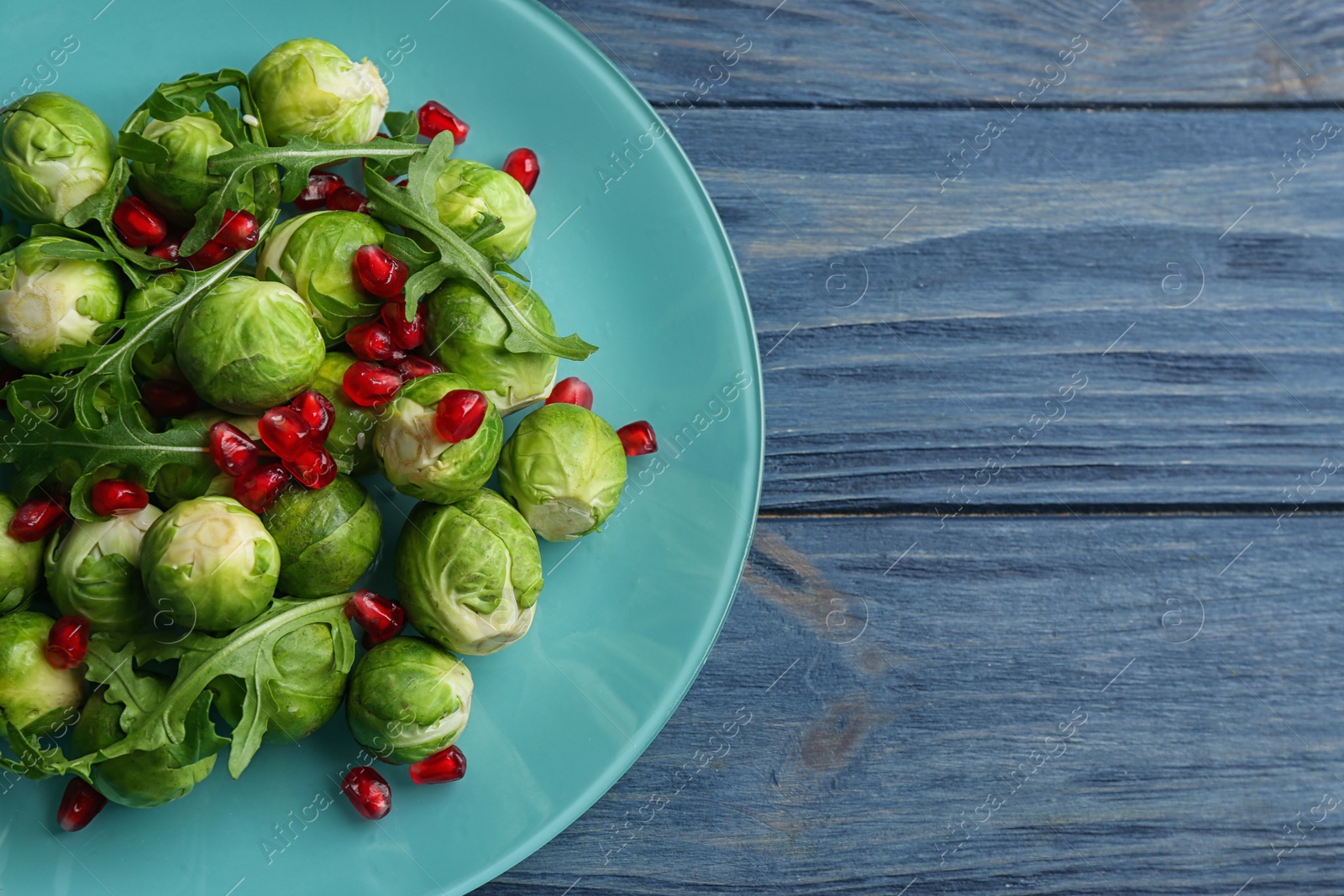 Photo of Tasty salad with Brussels sprouts on wooden table, top view. Space for text