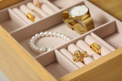 Photo of Jewelry box with many different accessories in wooden drawer, closeup