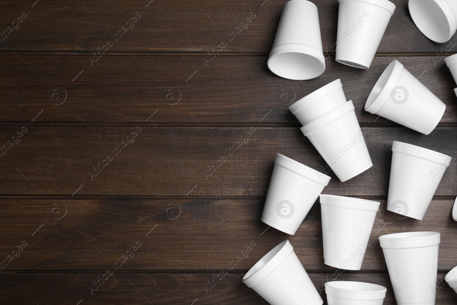 Photo of Many white styrofoam cups on wooden table, flat lay. Space for text