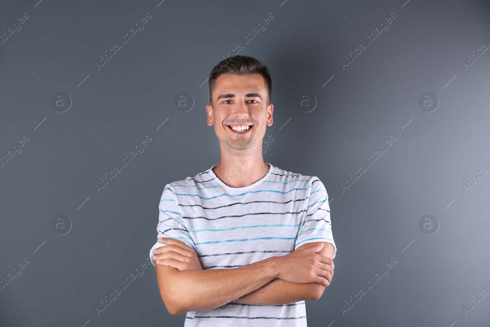 Photo of Handsome young man smiling on color background