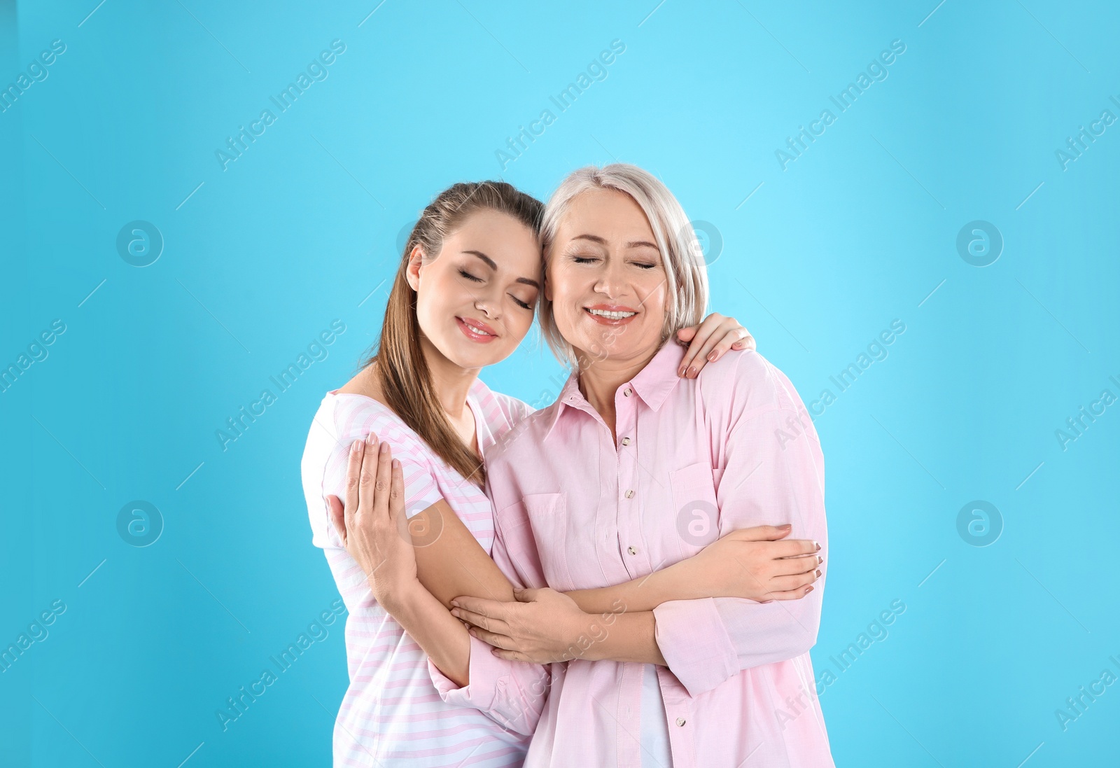 Photo of Portrait of young woman with her mature mother on color background