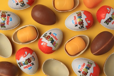 Sveti Vlas, Bulgaria - June 29, 2023: Kinder Surprise Eggs and plastic capsules on orange background, flat lay