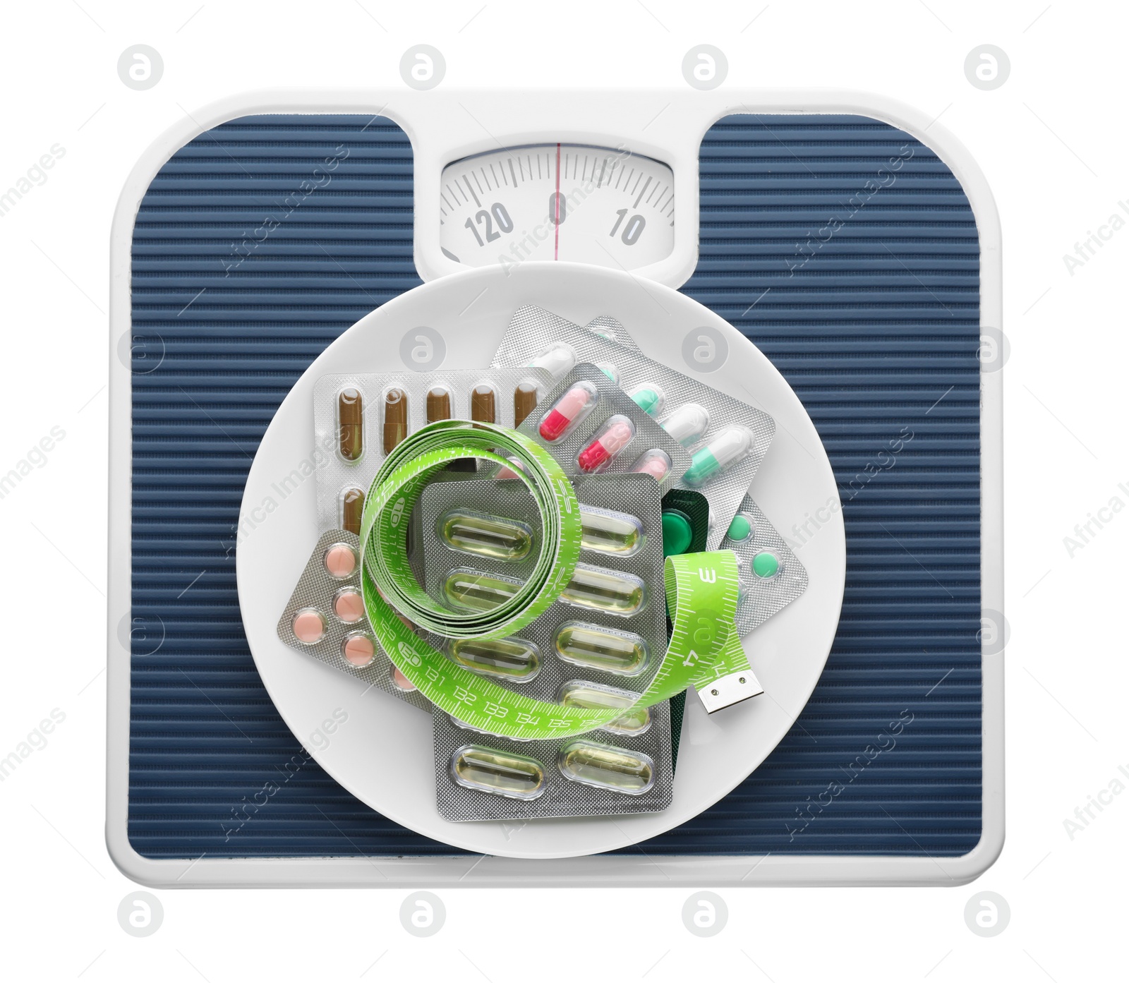 Photo of Scales with plate of pills and measuring tape on white background, top view