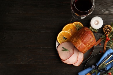 Photo of Flat lay composition with delicious ham on black wooden table, space for text. Christmas dinner