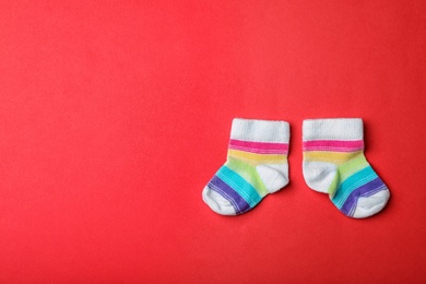 Pair of cute child socks and space for text on color background, top view