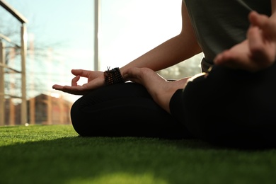 Photo of Young woman practicing yoga in sunlit room, closeup