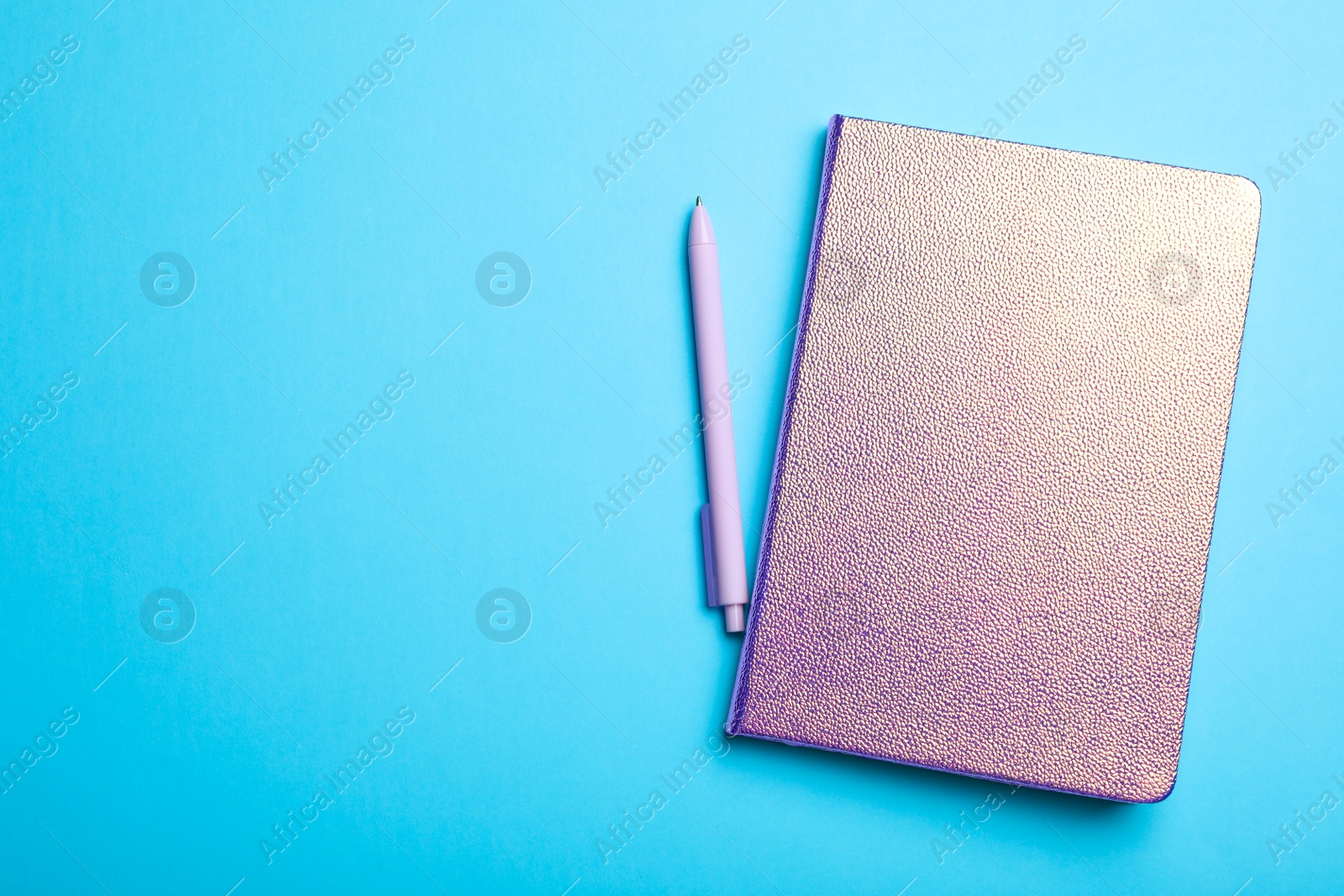 Photo of Stylish glitter notebook and pen on light blue background, flat lay. Space for text