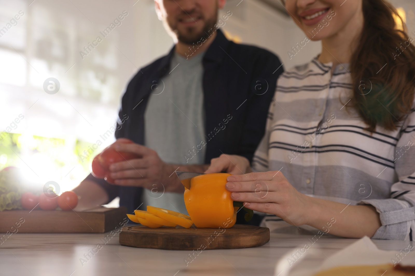 Photo of Lovely young couple cooking together in kitchen, closeup