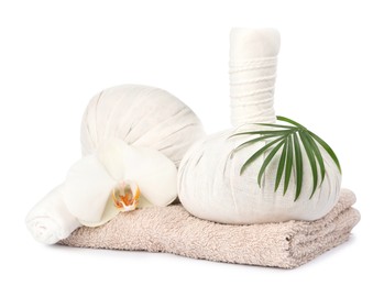 Photo of Herbal massage bags, flower, green leaf and towel on white background. Spa supply