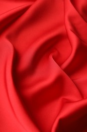 Photo of Crumpled red silk fabric as background, closeup