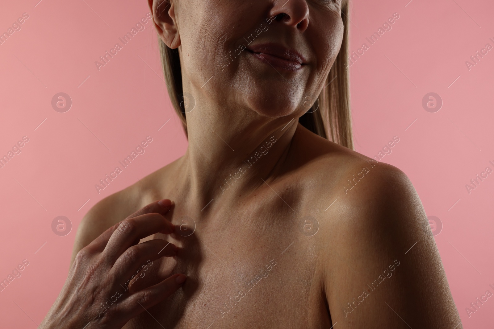 Photo of Mature woman with healthy skin on pink background, closeup