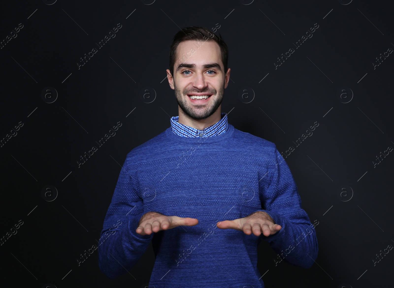 Photo of Man showing BLESS gesture in sign language on black background