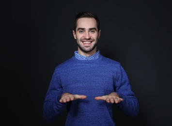 Man showing BLESS gesture in sign language on black background