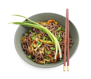 Photo of Stir-fry. Delicious cooked noodles with chicken in bowl and chopsticks isolated on white, top view