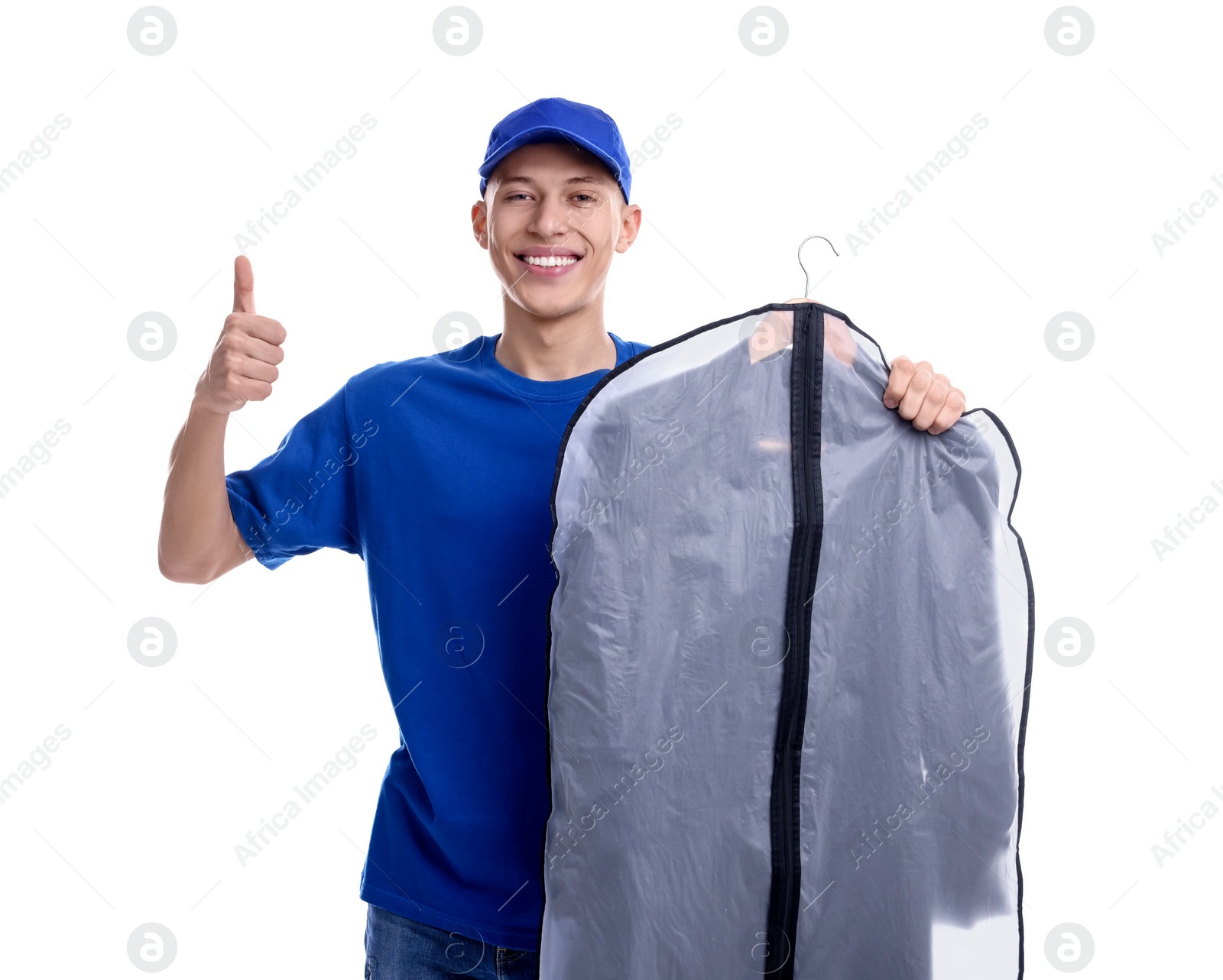Photo of Dry-cleaning delivery. Happy courier holding garment cover with clothes and showing thumbs up on white background