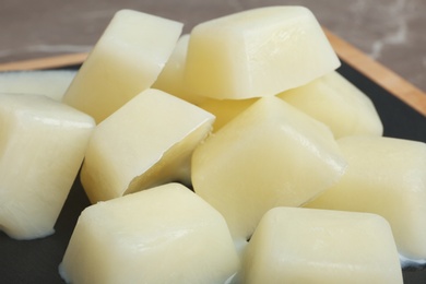 Photo of Ice cubes made with milk on board, closeup