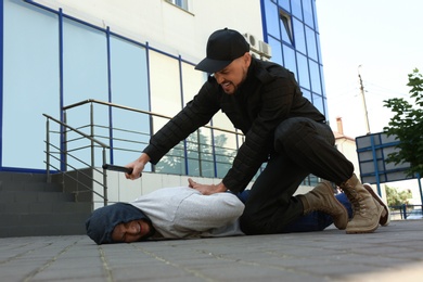 Police officer arresting dangerous criminal on street