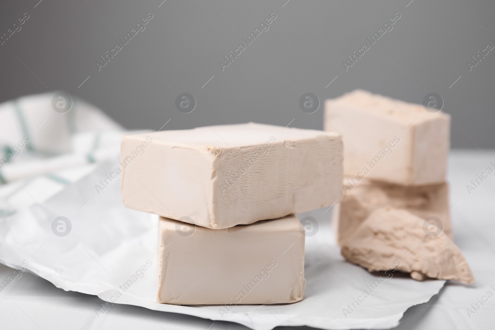 Photo of Blocks of compressed yeast on white table, closeup