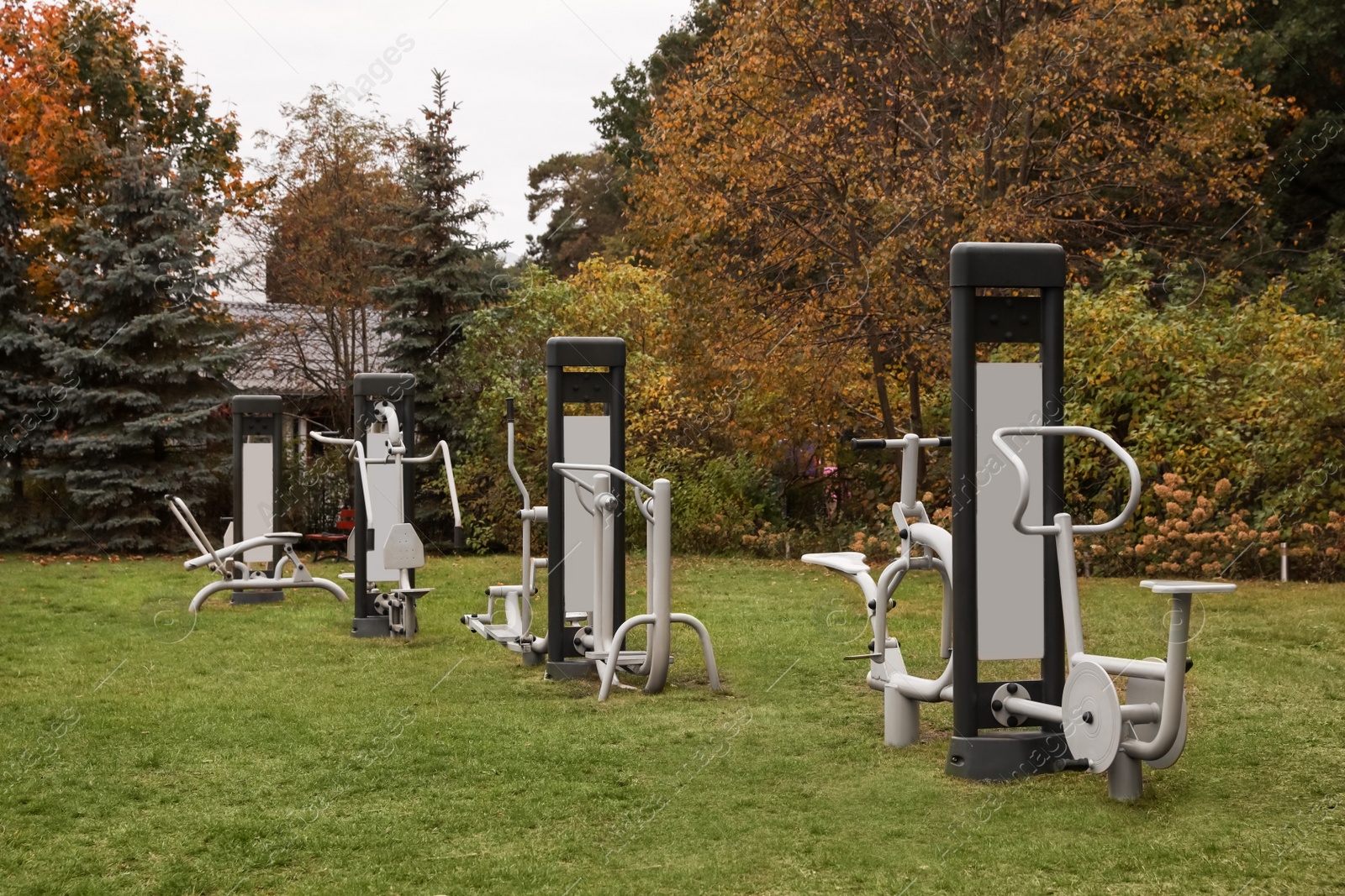 Photo of Many different metal sport simulators on green grass in park