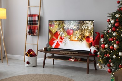 Stylish living room interior with modern TV and Christmas tree