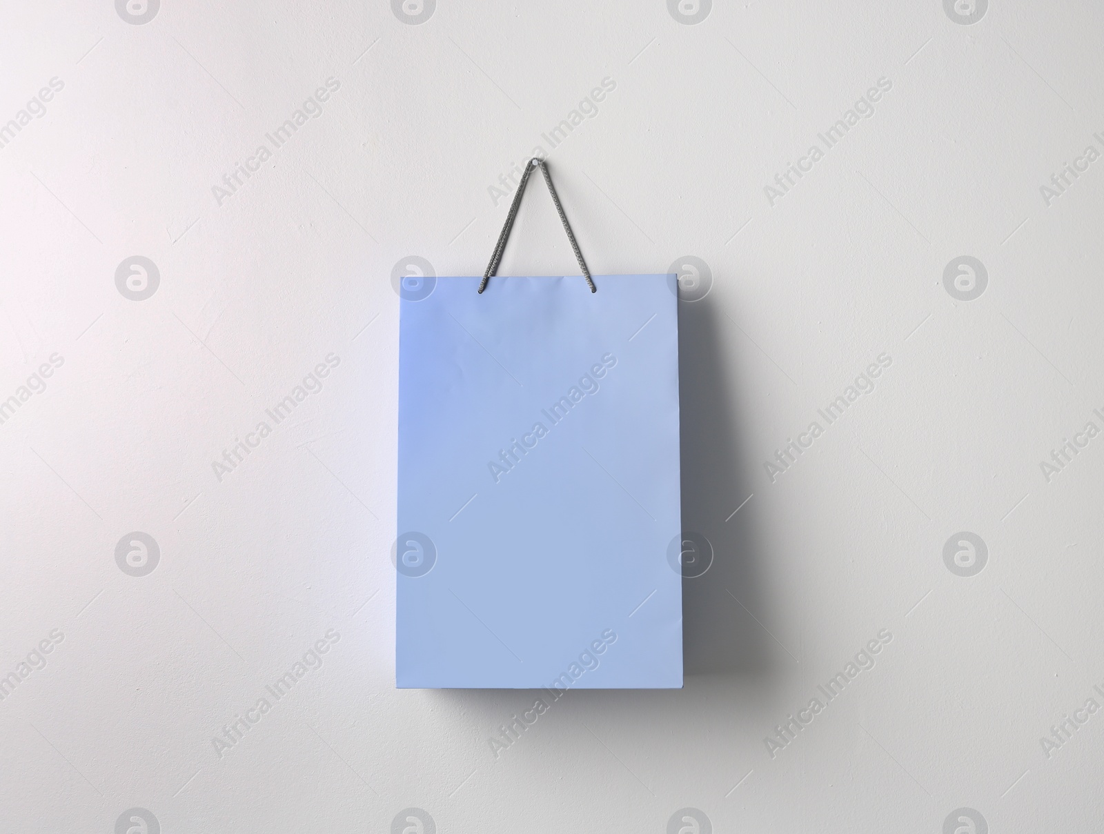 Photo of Paper shopping bag hanging on white wall