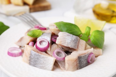 Photo of Tasty marinated fish, onion and basil on plate, closeup