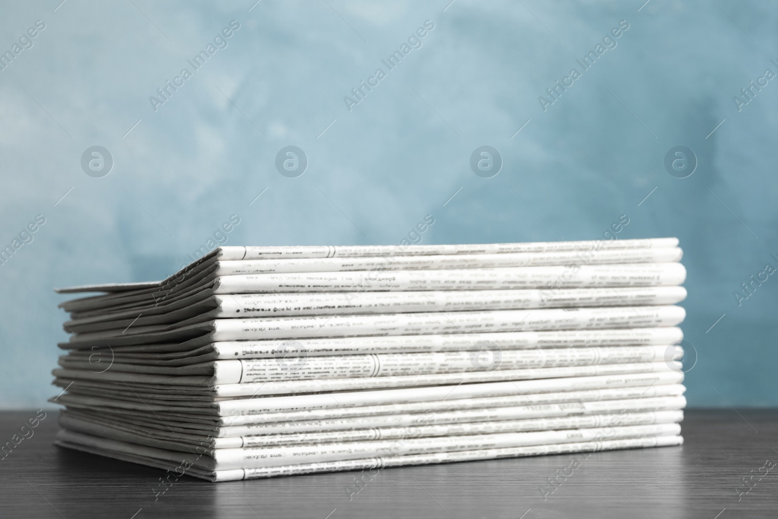 Photo of Stack of newspapers on blue background. Journalist's work