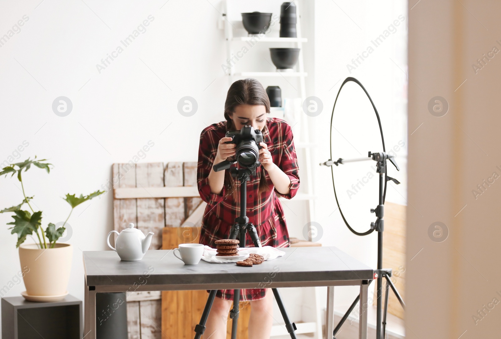 Photo of Young woman with professional camera taking food photo in studio