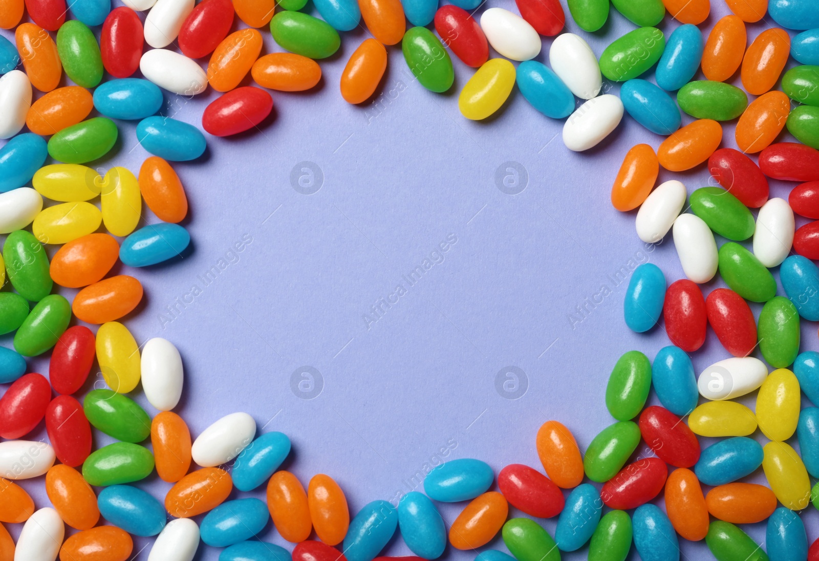 Photo of Frame made of bright jelly candies on color background, flat lay. Space for text