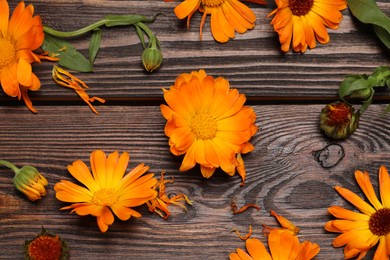 Photo of Beautiful fresh calendula flowers on wooden table, flat lay